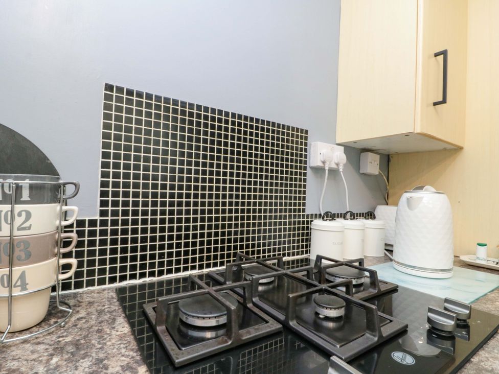 A kitchen with a stove, kettle, and storage jars at 46 Nelson Street in Bridlington