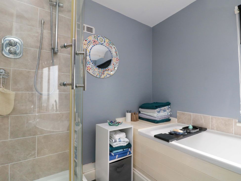 A bathroom with a shower, bathtub, and towels at 46 Nelson Street Bridlington