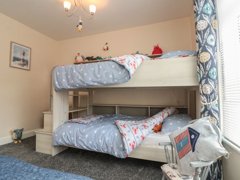 A bedroom with a bunk bed and wall art at Blackberry Cottage in Bridlington