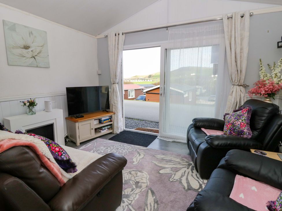 A living room with a television and sofa at The Comfort Den near Aberystwyth