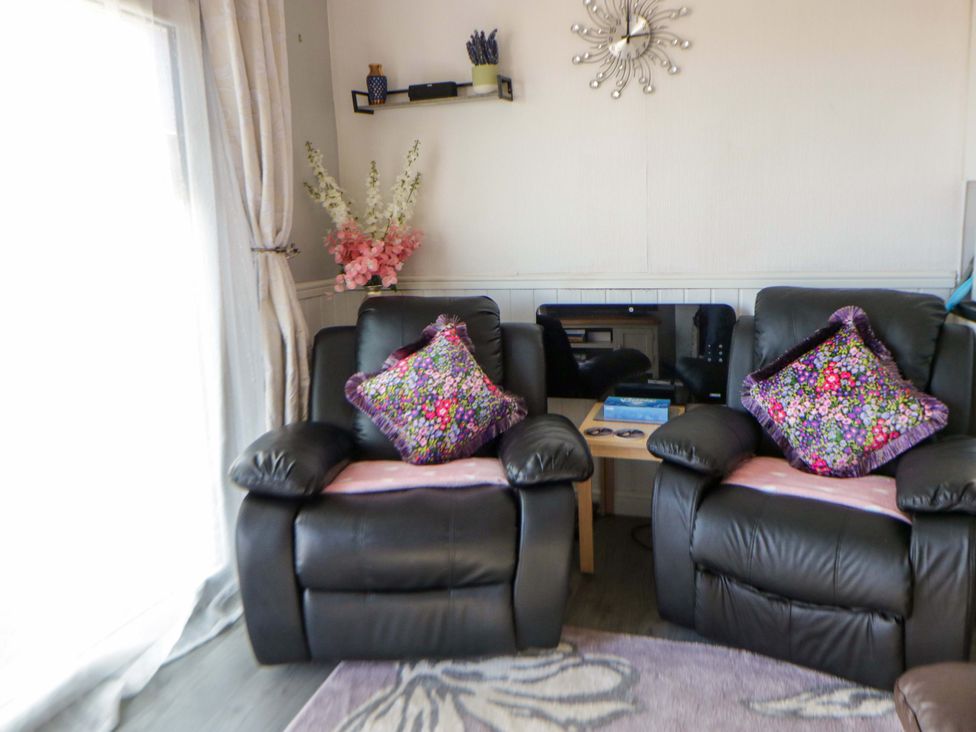 A living room with black recliners and a small table at The Comfort Den near Aberystwyth