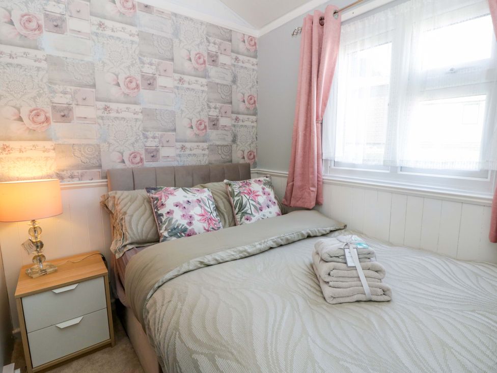 A bedroom with a bed and lamp at The Comfort Den near Aberystwyth