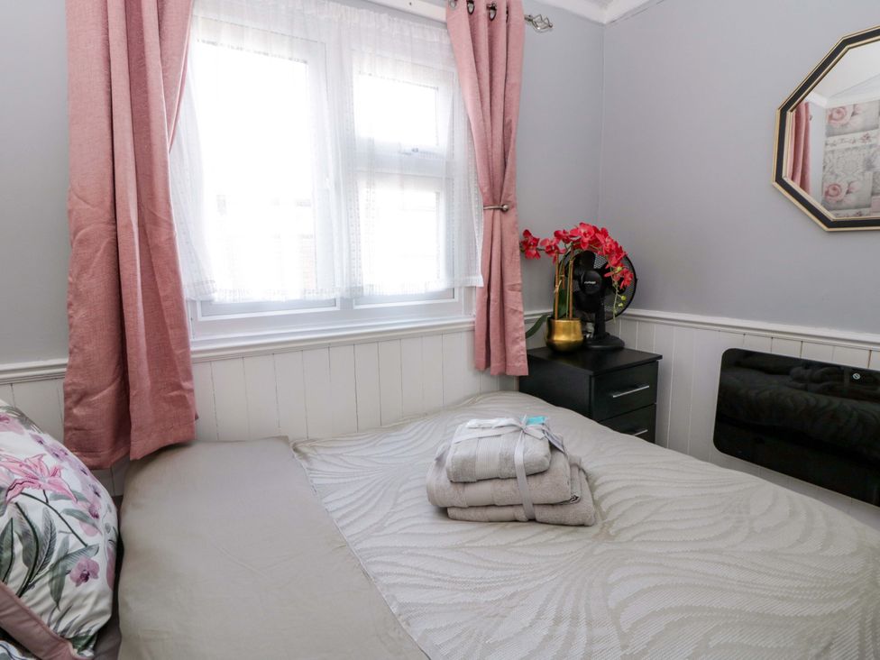 A bedroom with a bed and window at The Comfort Den near Aberystwyth
