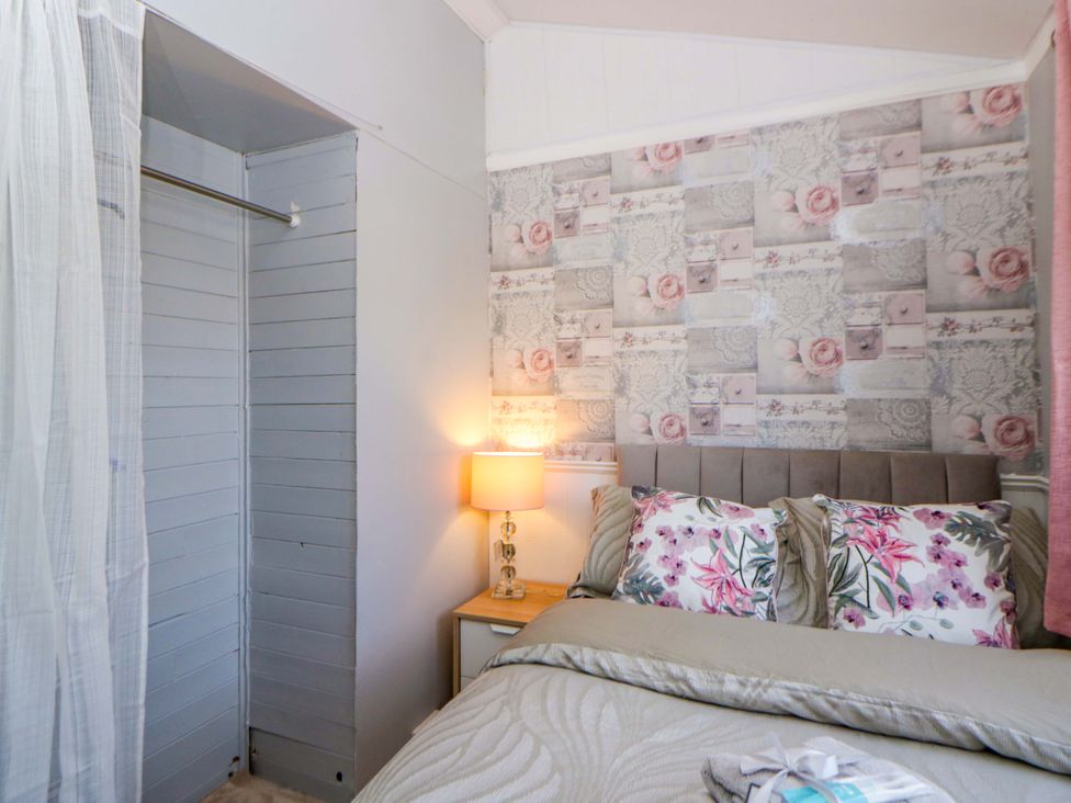 A bedroom with a bed and bedside table at The Comfort Den near Aberystwyth