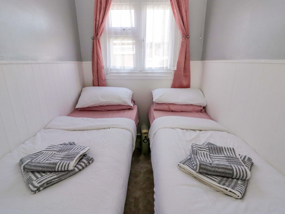 A bedroom with two beds and a window at The Comfort Den near Aberystwyth