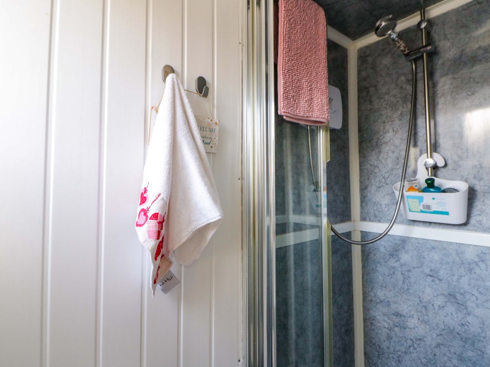 A bathroom with a shower and towels at The Comfort Den near Aberystwyth