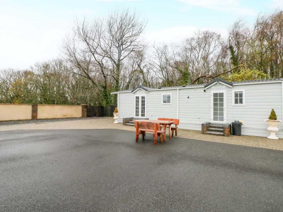 An outdoor space with a table and chairs at Meadows Farm Lodge in Gorseinon
