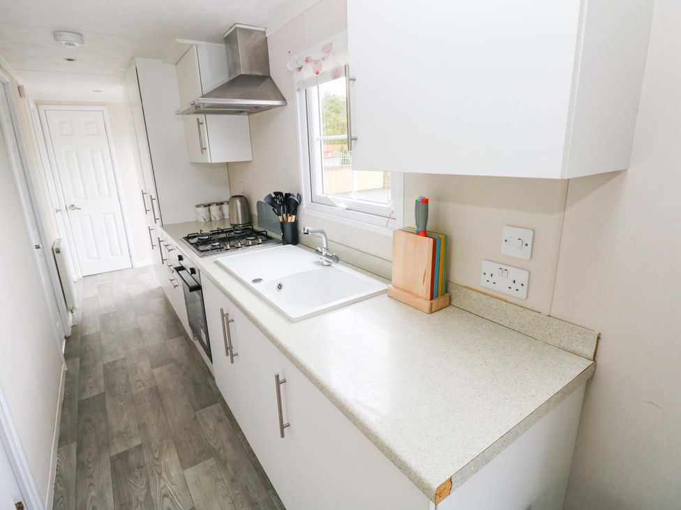 A kitchen with a sink and stove at Meadows Farm Lodge in Gorseinon
