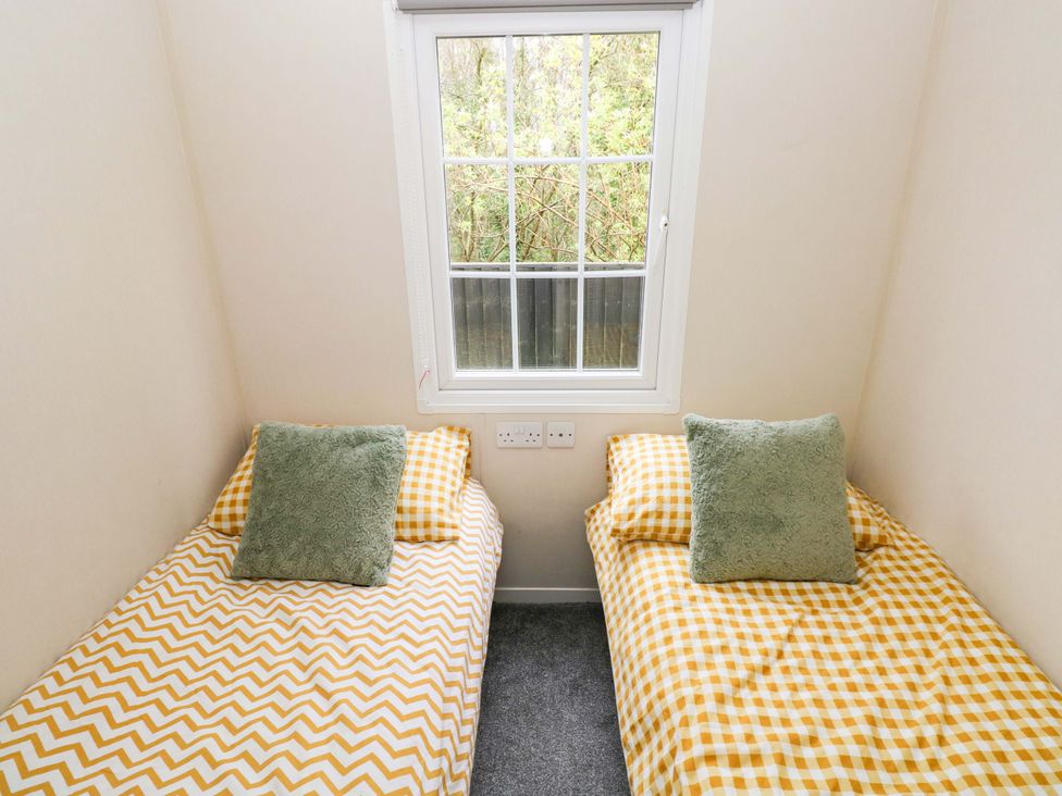 A bedroom with two single beds at Meadows Farm Lodge in Gorseinon