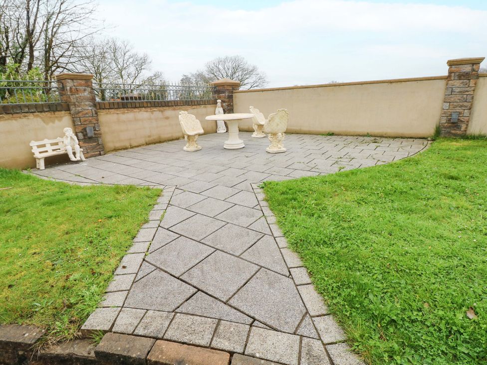 A garden patio with table and chairs at Meadows Farm Lodge in Gorseinon