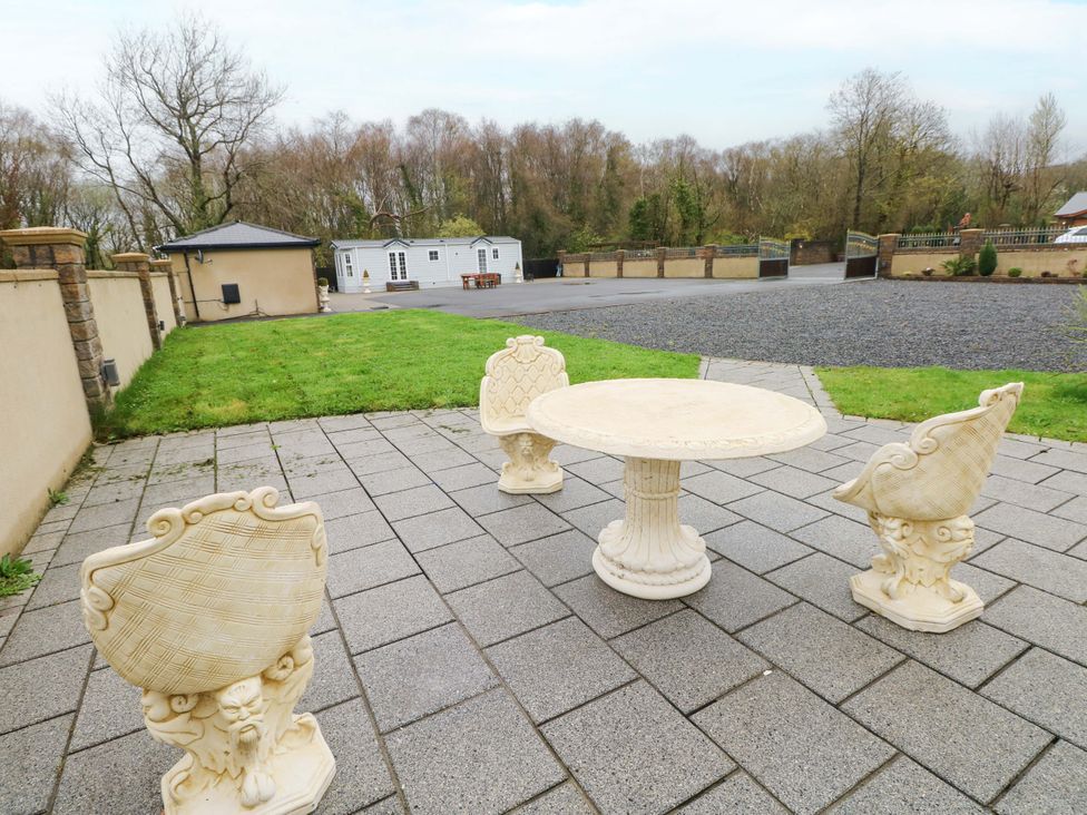 A table with chairs in an outdoor area at Meadows Farm Lodge in Gorseinon