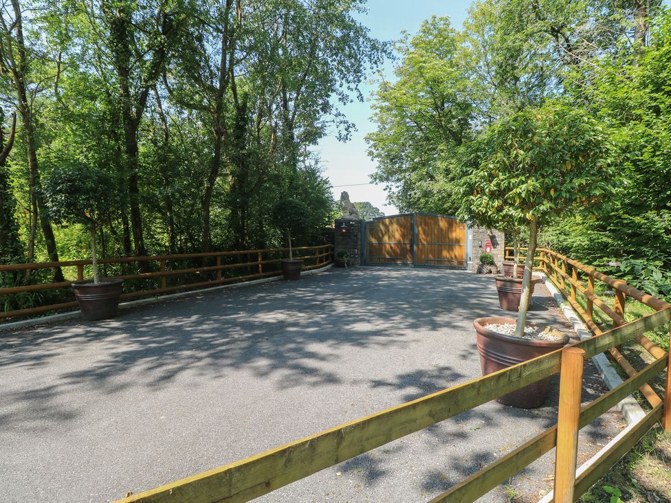 An outdoor area with trees and a gate at Meadows Farm Lodge in Gorseinon