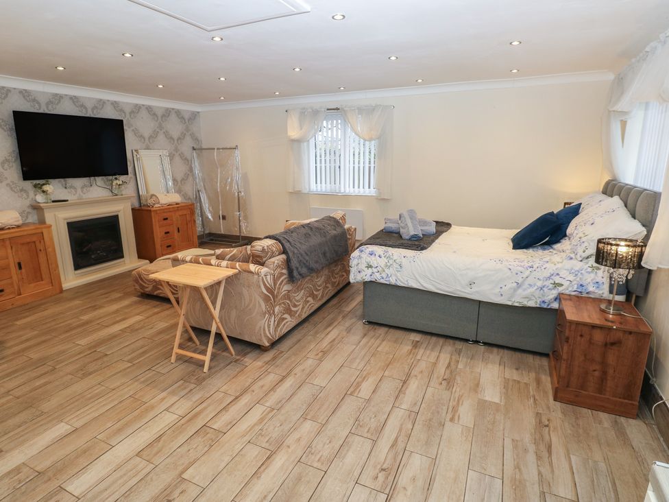 A bedroom featuring a bed and a sofa at Annexe @ Meadows Farm, Swansea