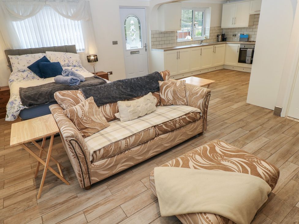 A living room with a sofa and bed at Annexe @ Meadows Farm in Swansea