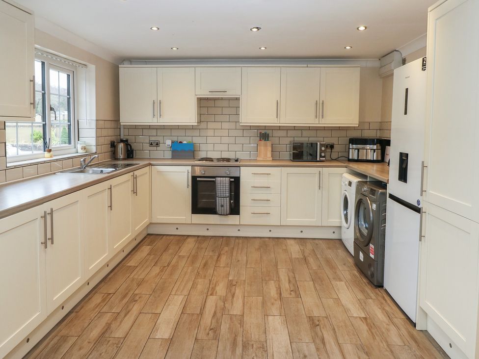 A kitchen with appliances and cabinets at Annexe @ Meadows Farm in Swansea
