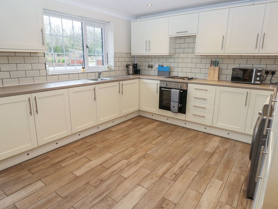 A kitchen with cabinets and appliances at Annexe @ Meadows Farm in Swansea