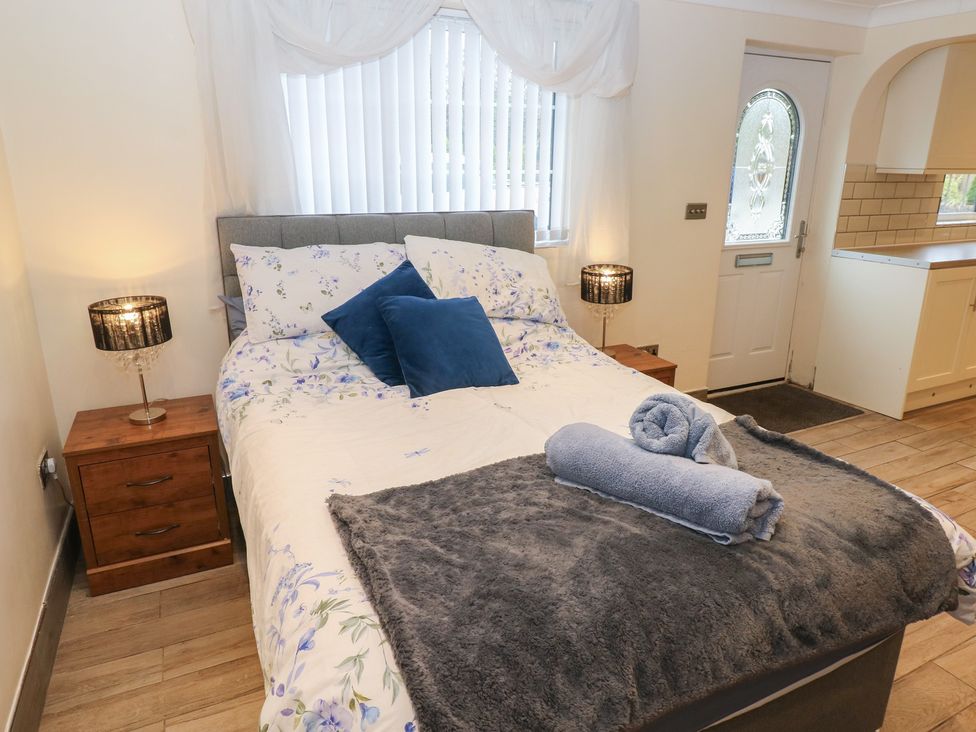 A bedroom with a bed and bedside table at Annexe @ Meadows Farm Swansea