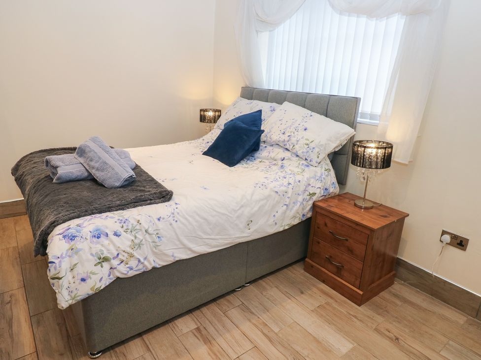A bedroom with a bed and bedside table at Annexe @ Meadows Farm Swansea
