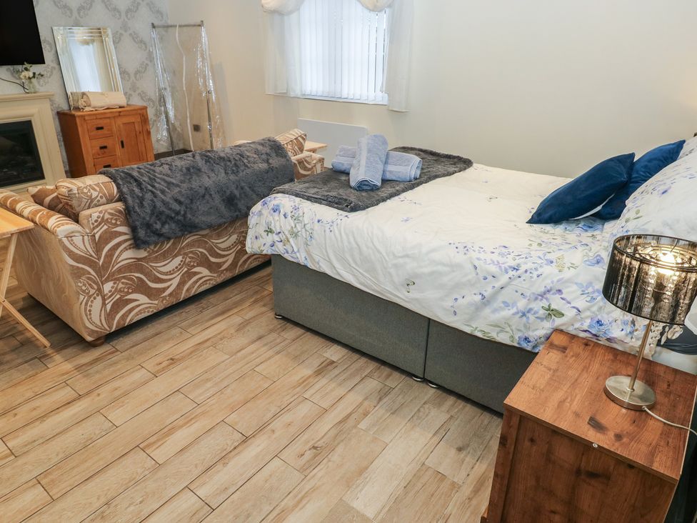 A bedroom with a bed and a sofa at Annexe @ Meadows Farm Swansea