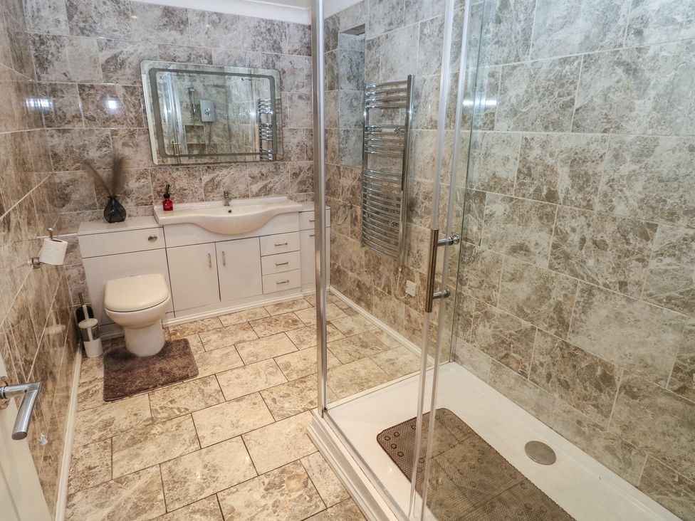 A bathroom with a toilet, sink, shower and towel radiator at Annexe @ Meadows Farm in Swansea