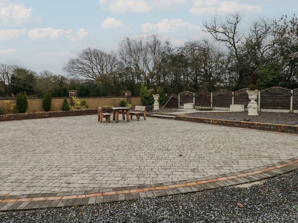 A garden with paving stones and a table with chairs at Annexe @ Meadows Farm in Swansea
