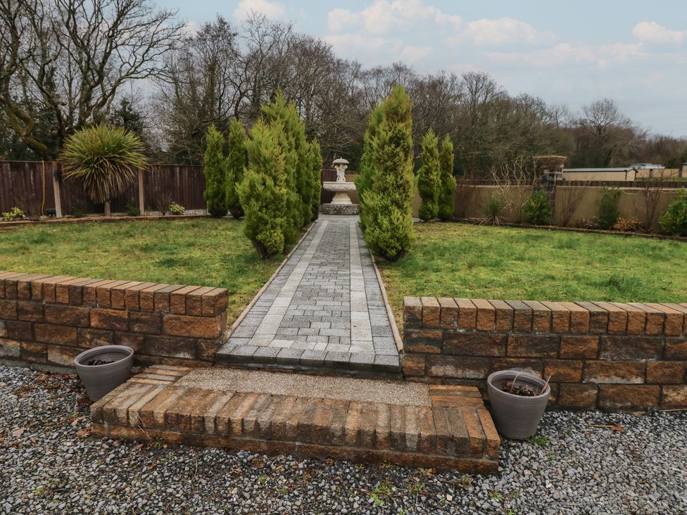 A garden with a stone pathway and a fountain at Annexe @ Meadows Farm Swansea