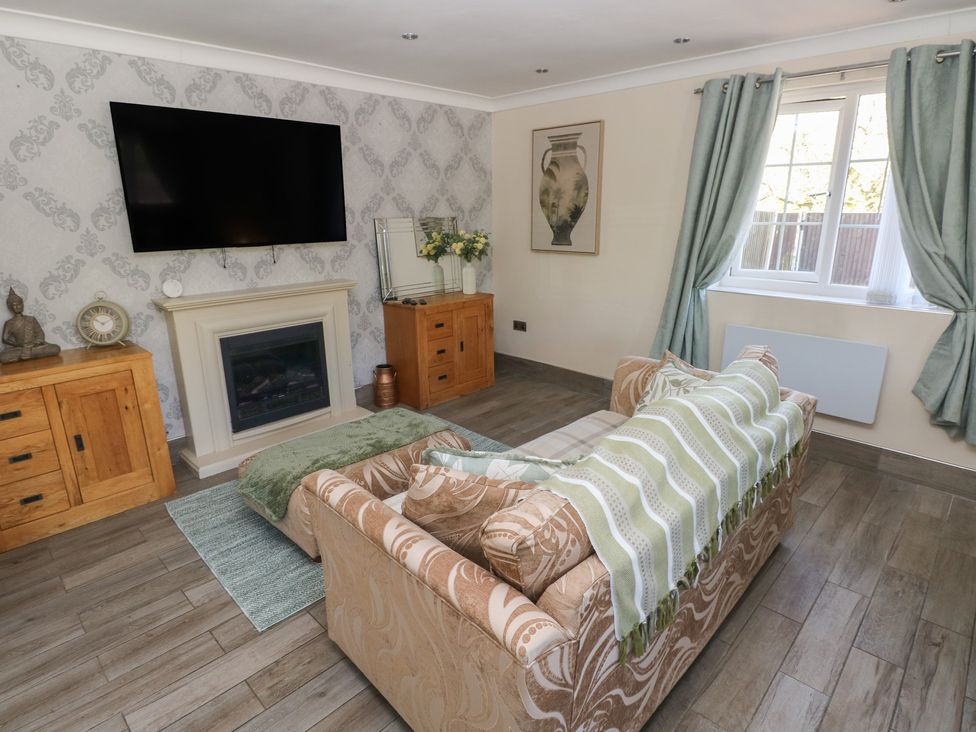 A living room with a sofa and television at Annexe @ Meadows Farm Gorseinon