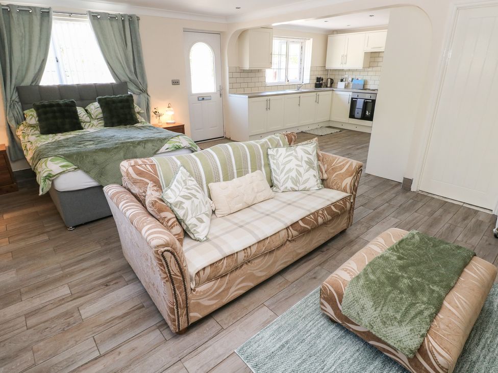 A studio apartment with a bed and kitchen area at Annexe @ Meadows Farm Gorseinon