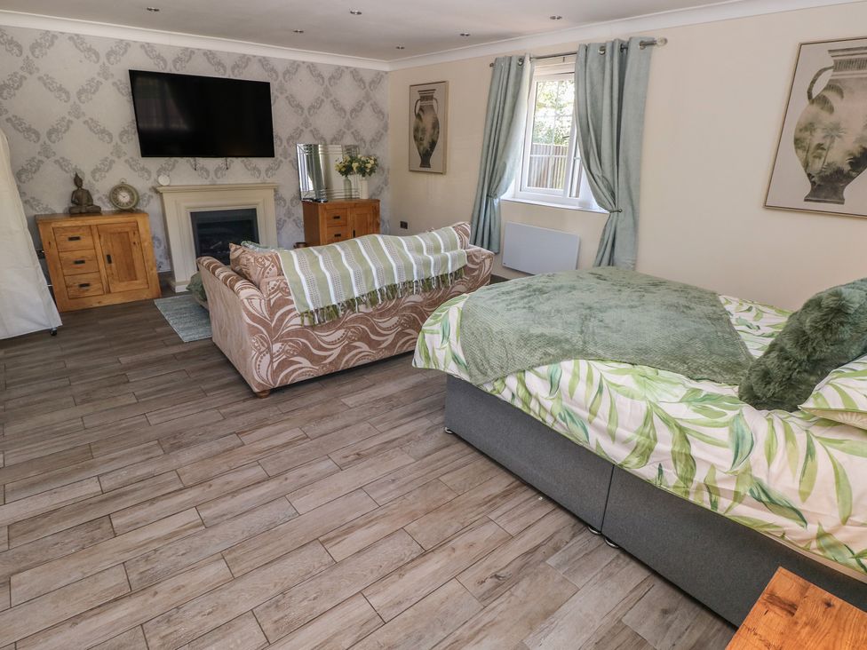 A living room with a sofa and bed at Annexe @ Meadows Farm Gorseinon