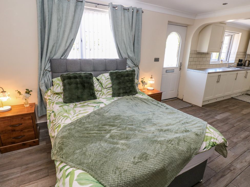 A bedroom with a bed and bedside table at Annexe @ Meadows Farm in Gorseinon