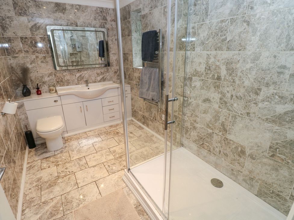 A bathroom with a shower and sink at Annexe @ Meadows Farm in Gorseinon