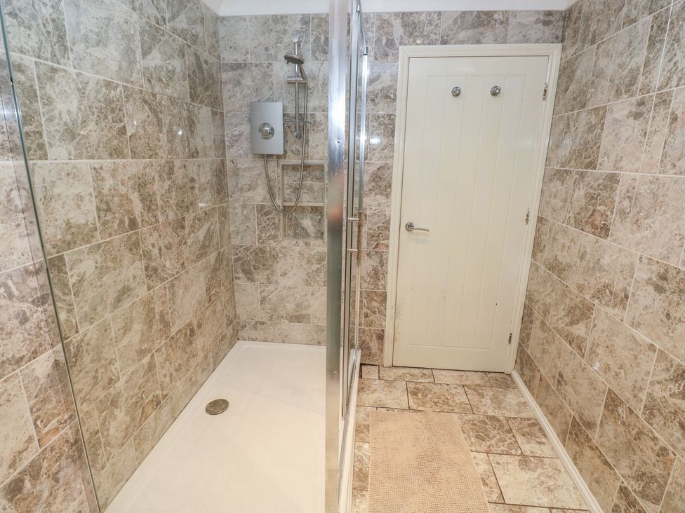 A bathroom with a shower and door at Annexe @ Meadows Farm in Gorseinon