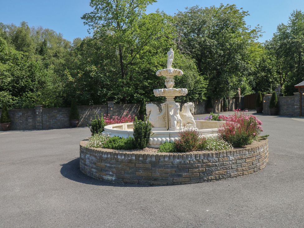 An outdoor area featuring a fountain surrounded by flowers at Annexe @ Meadows Farm Gorseinon