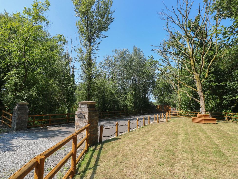 An outdoor area with a gravel road and trees at Annexe @ Meadows Farm Gorseinon