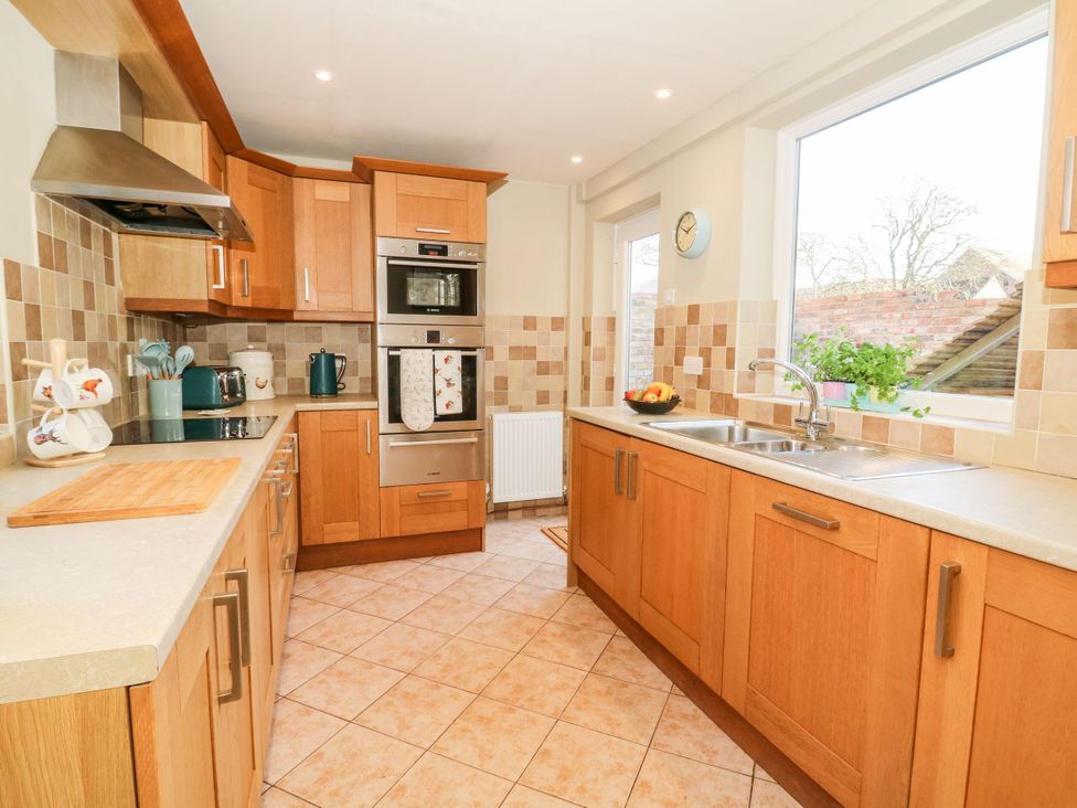 A kitchen with wooden cabinets and appliances at The Old Post Office in York