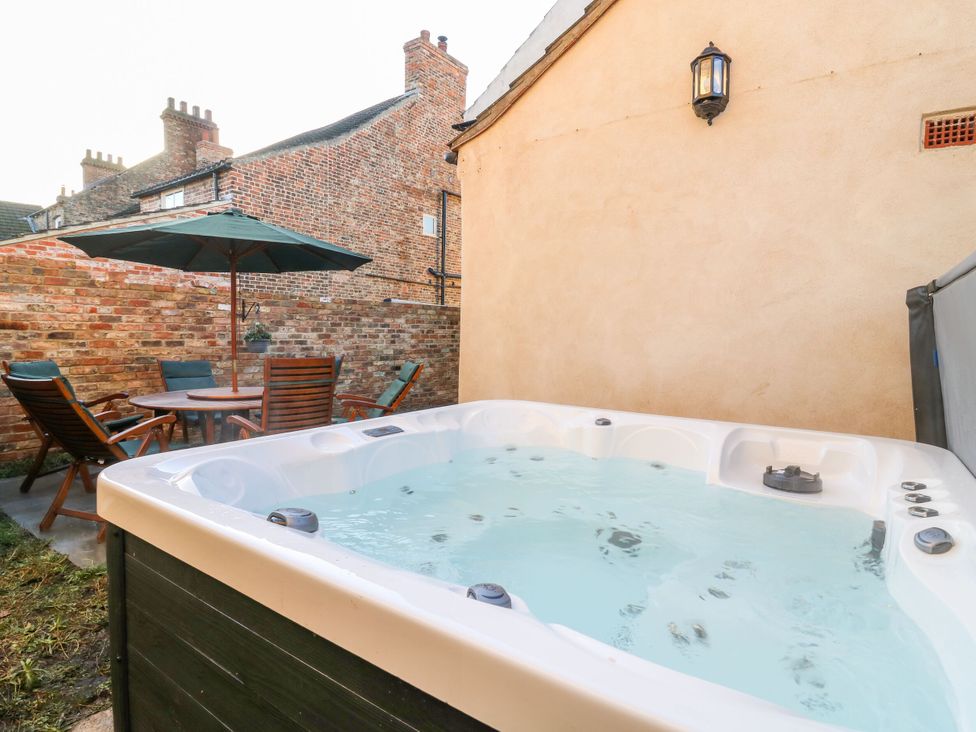 A hot tub and seating area in a garden at The Old Post Office York