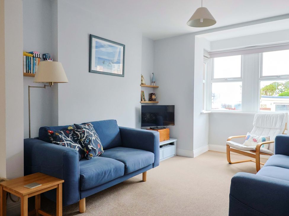 A living room with sofas and a television at 4 Peaslands Road Sidmouth