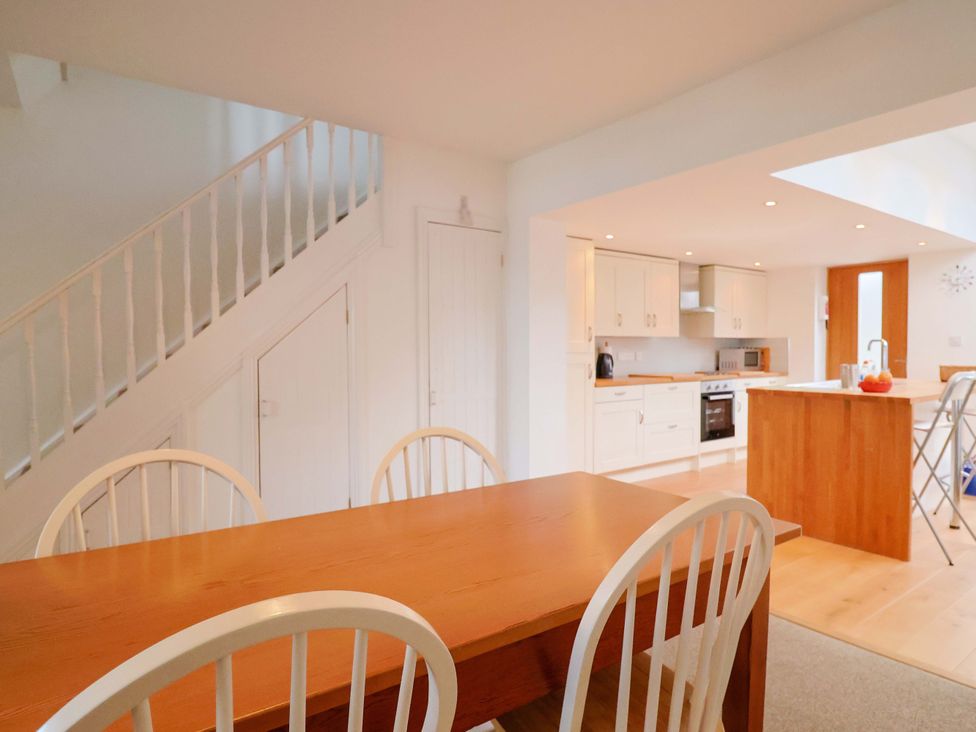 A kitchen with a dining area and staircase at 4 Peaslands Road in Sidmouth