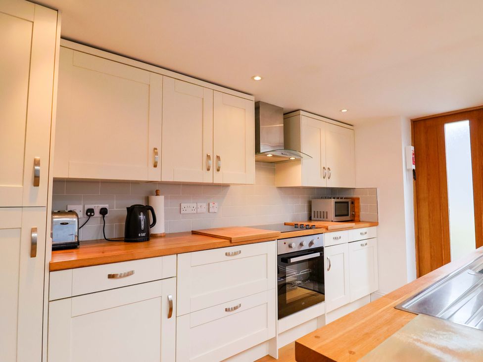 A kitchen with cabinets, oven, toaster and kettle at 4 Peaslands Road in Sidmouth