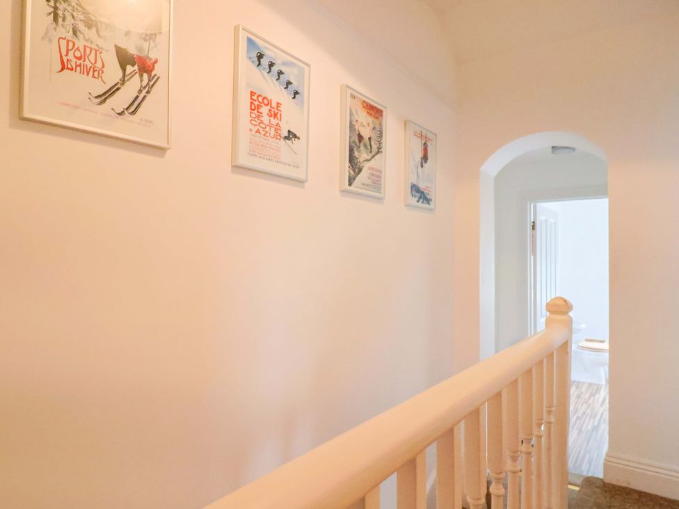 A hallway with framed posters on the wall at 4 Peaslands Road in Sidmouth