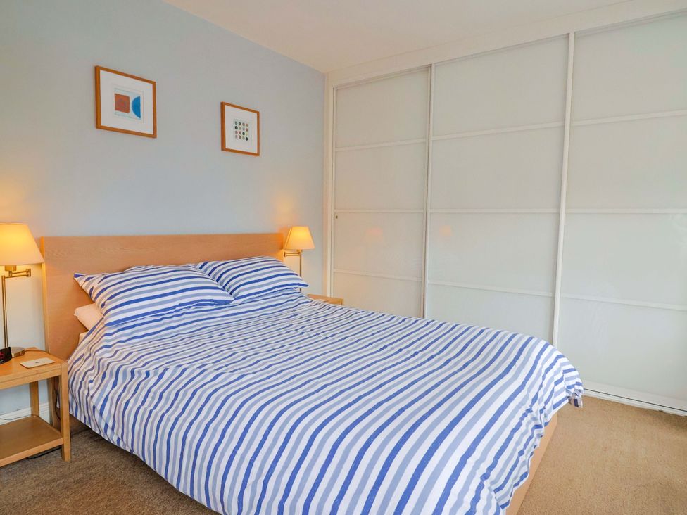 A bedroom with a bed and bedside tables at 4 Peaslands Road in Sidmouth