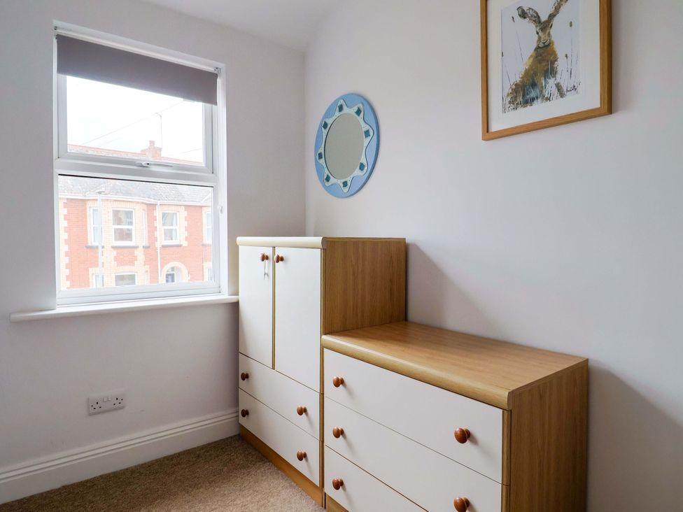 A bedroom with a drawer unit and a mirror at 4 Peaslands Road Sidmouth