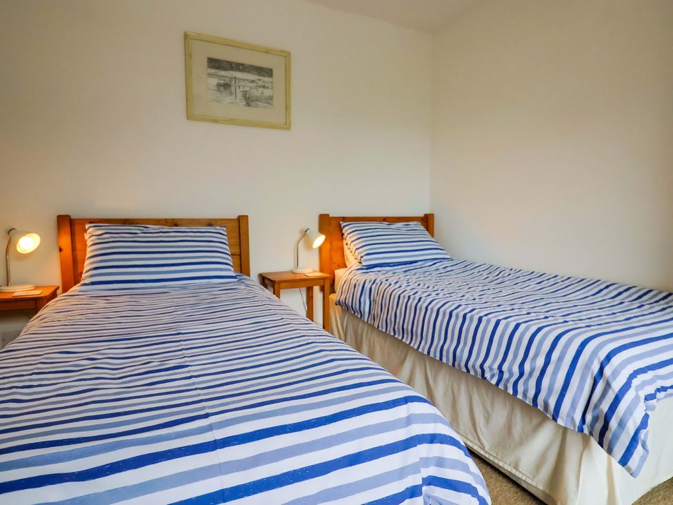 A bedroom with two single beds and a painting at 4 Peaslands Road Sidmouth