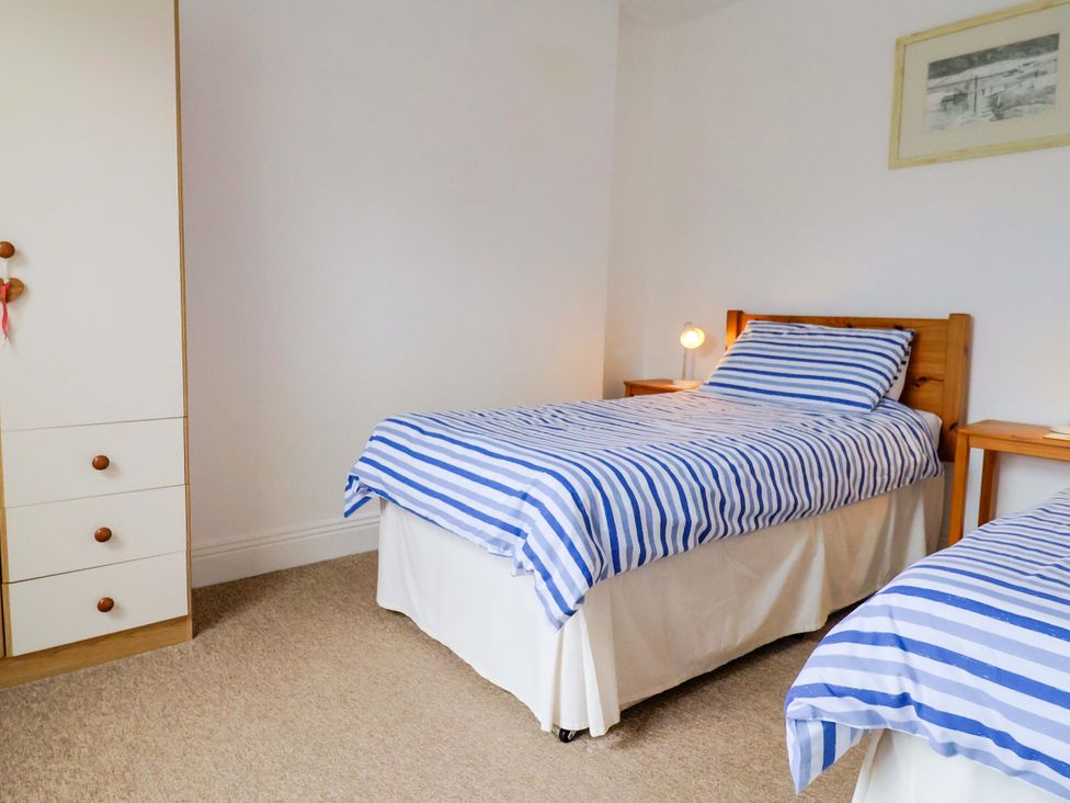 A bedroom with two beds and a wardrobe at 4 Peaslands Road Sidmouth