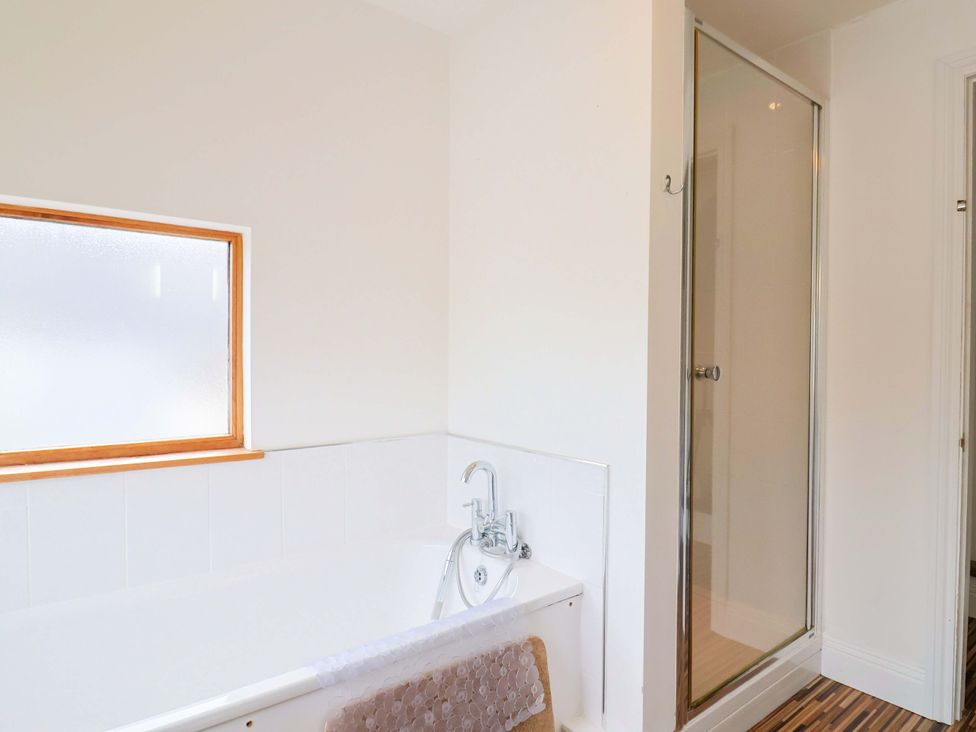 A bathroom featuring a bathtub and a shower at 4 Peaslands Road Sidmouth