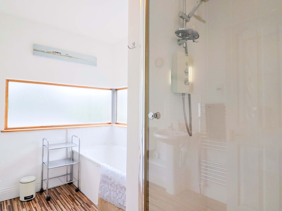 A bathroom featuring a bathtub and shower at 4 Peaslands Road Sidmouth