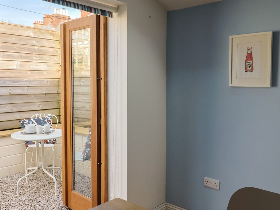 A room with a door leading to a table and chairs at 4 Peaslands Road Sidmouth