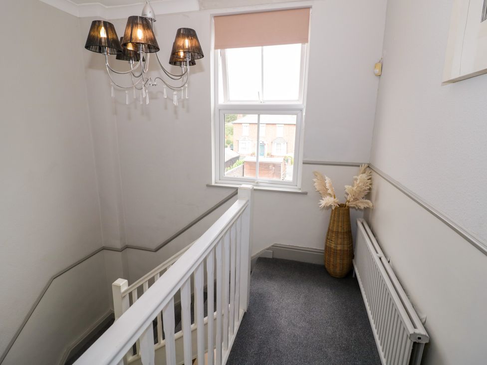 A staircase with a chandelier and a decorative vase at 141 Barnards Green Road Barnard's Green, Malvern