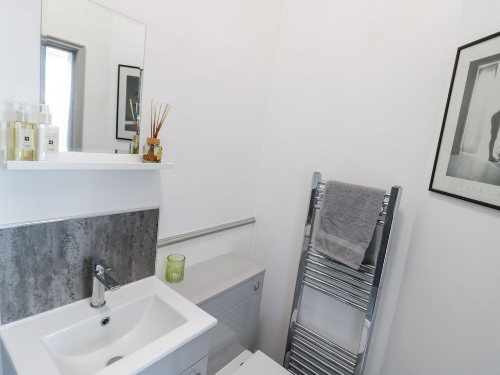 A bathroom featuring a sink, mirror, towel rack, and shelf at 141 Barnards Green Road, Barnard's Green, Malvern