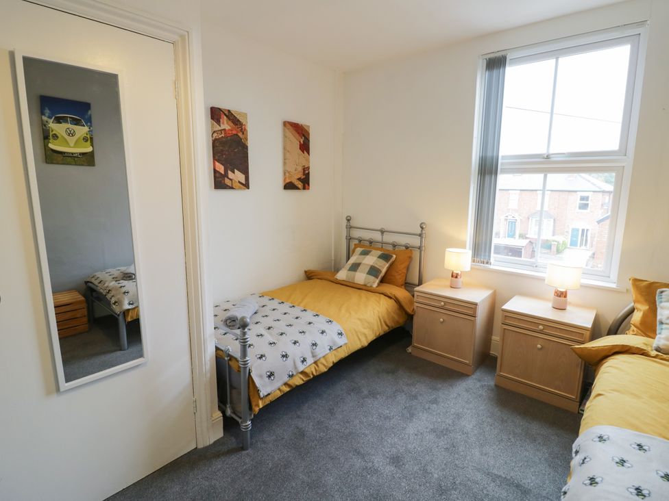 A bedroom with two beds and a mirror at 141 Barnards Green Road, Barnard's Green, Malvern